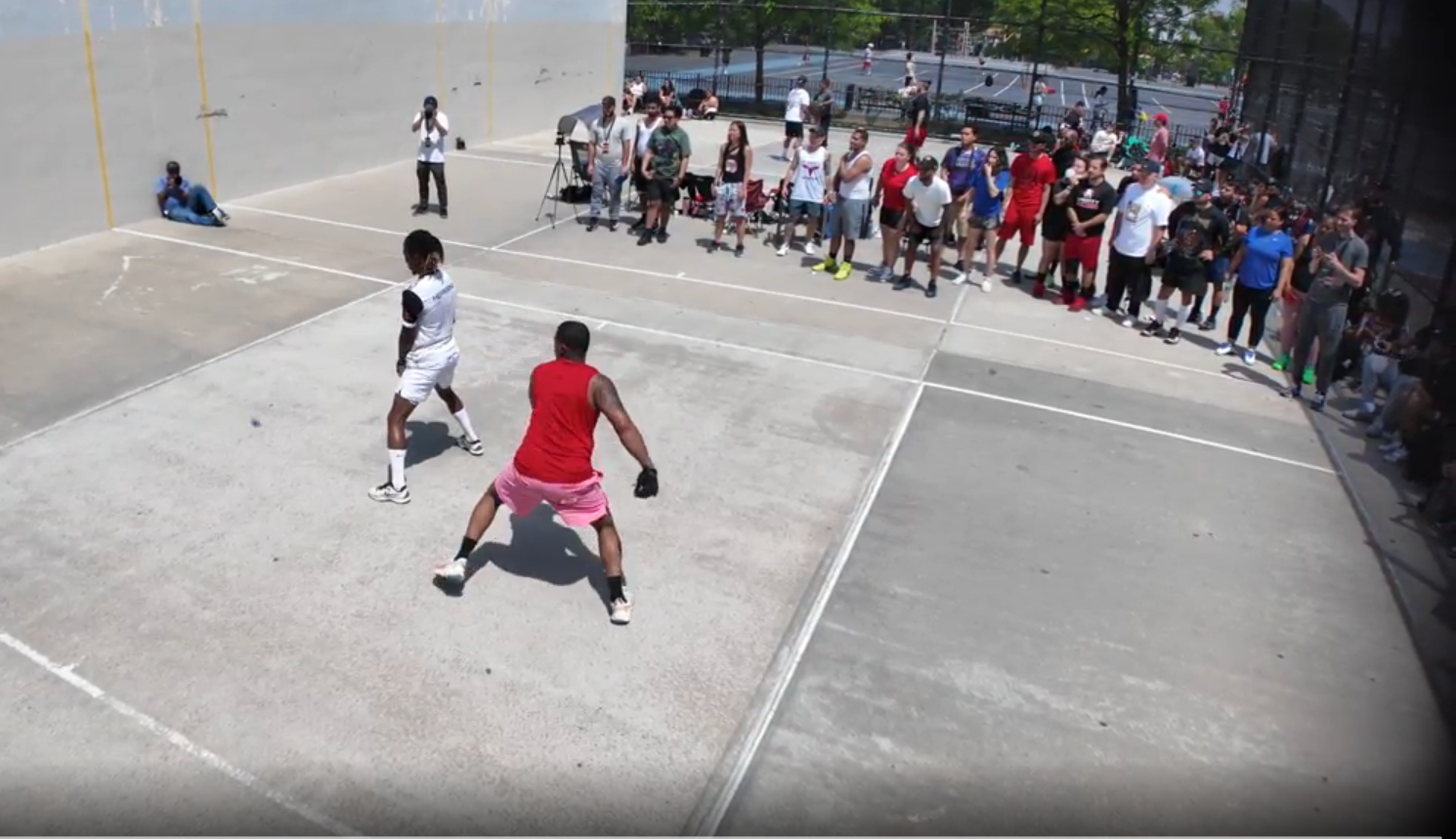 Two MegaWall players rallying on a one-wall court in front of a packed sideline crowd